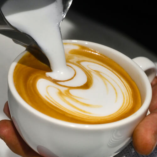 Latte art rosetta made with steamed milk foam on a freshly pulled Espresso Virtuoso.