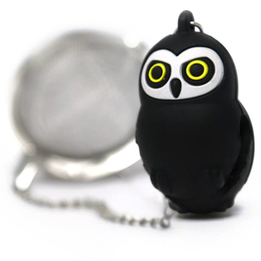 A stainless steel mesh tea leaf infuser in the shape of an owl with black body and yellow eyes, complete with a chain for hanging.